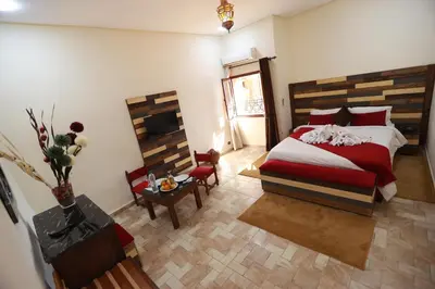 a bedroom with a bed and a table and a chair at Kasbah Tizimi in Erfoud