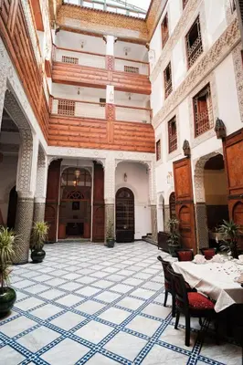 a room with a table and chairs in a building at Riad Dar Laura in Fès