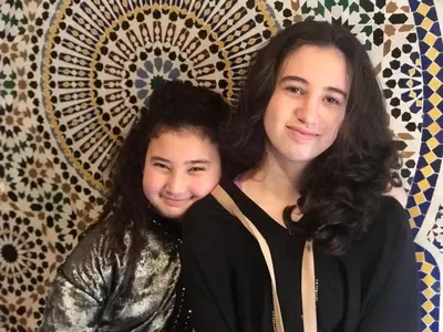 two women posing for a picture in front of a wall at Riad Dar Laura in Fès