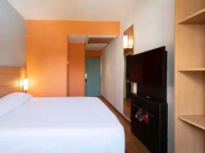 a bedroom with a bed and a flat screen tv at Ibis Fes in Fès