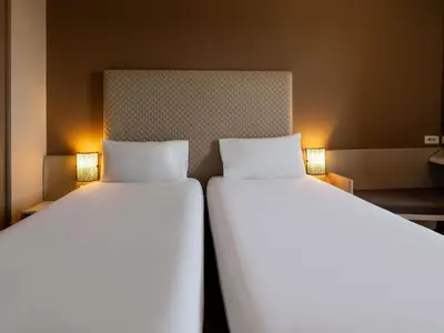 two beds sitting next to each other in a room at Ibis Ouarzazate Centre in Ouarzazate