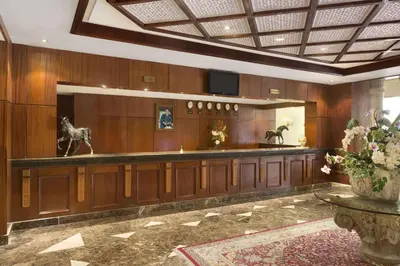 a lobby with wood paneling and statues of horses on the wall at Ramada By Wyndham Fes in Fès