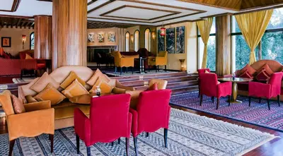 a hotel lobby with red chairs and a couch at Les Mérinides in Fès