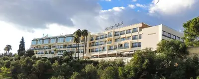 a large white building with trees in front of it at Les Mérinides in Fès