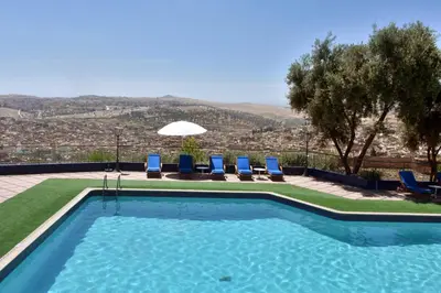 a swimming pool with chairs and a view of a city at Les Mérinides in Fès