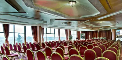 a conference room with red chairs and windows at Les Mérinides in Fès