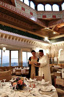a man and a woman standing in a restaurant at Les Mérinides in Fès