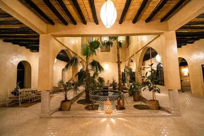 a lobby with potted plants in a building at Kasbah Mohayut in Merzouga