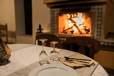 a table with a white plate and a fireplace at Kasbah Mohayut in Merzouga
