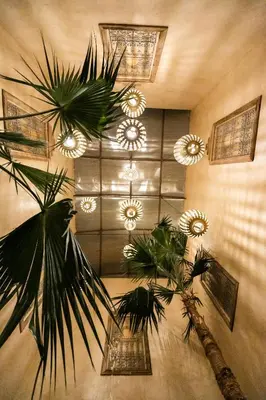 a room with a bunch of chandeliers and plants at Kasbah Mohayut in Merzouga
