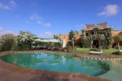 a swimming pool in front of a house at Riad Al Mendili Private Resort & Spa in Had Abdallah Rhiat