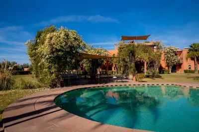 a swimming pool in front of a house at Riad Al Mendili Private Resort & Spa in Had Abdallah Rhiat