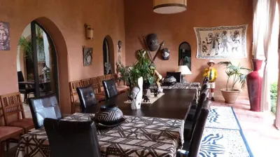 a dining room with a long table and chairs at Riad Al Mendili Private Resort & Spa in Had Abdallah Rhiat