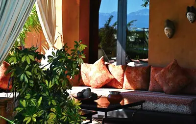 a living room with a couch with pillows at Riad Al Mendili Private Resort & Spa in Had Abdallah Rhiat