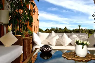 a white couch sitting on a patio with pillows at Riad Al Mendili Private Resort & Spa in Had Abdallah Rhiat