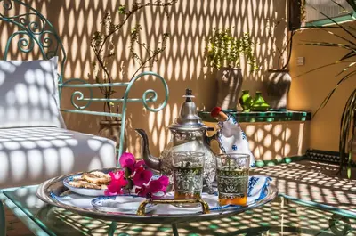 a glass table with a plate of food and drinks at Riad Zamane Fès - Boutique & Spa in Fès