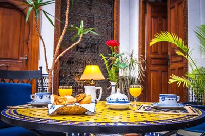 a table with a yellow and blue table cloth on it at Riad Zamane Fès - Boutique & Spa in Fès