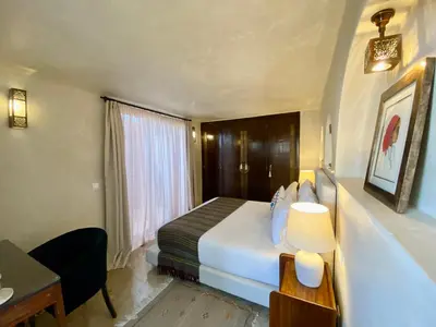 a hotel room with a large bed and a desk at Riad Zamane Fès - Boutique & Spa in Fès