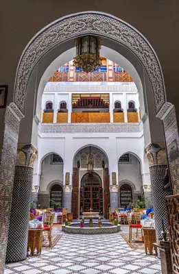 an archway in a building with tables and chairs at Riad El Yacout in Fès