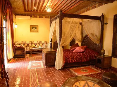 a bedroom with a canopy bed and a couch at Riad El Yacout in Fès
