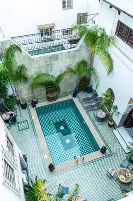 an overhead view of a swimming pool with palm trees at Riad El Yacout in Fès
