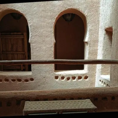 a building with two arched windows and a bench at Kasbah ait Moussa in Kalaat MGouna