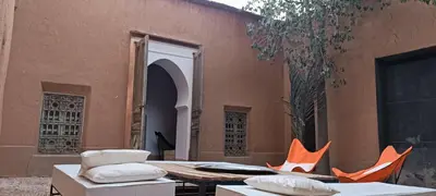 an outdoor patio with a table and chairs and a building at Kasbah ait Moussa in Kalaat MGouna