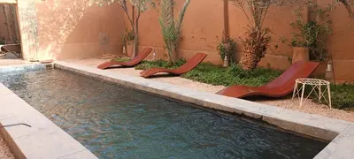a row of chairs sitting next to a swimming pool at Kasbah ait Moussa in Kalaat MGouna