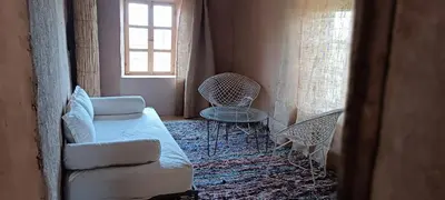 a room with a bed and a chair and a window at Kasbah ait Moussa in Kalaat MGouna
