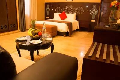 a hotel room with a bed and a table with fruit at Palais Du Desert Hotel & Spa in Erfoud