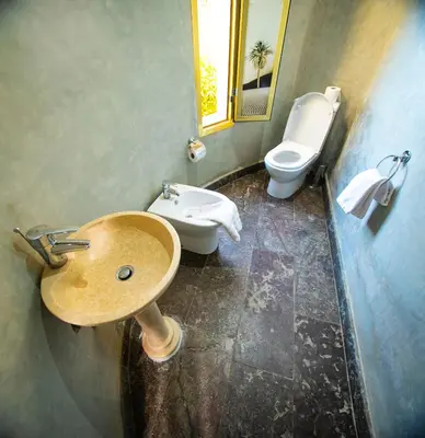 a bathroom with a sink and a toilet at Palais Du Desert Hotel & Spa in Erfoud