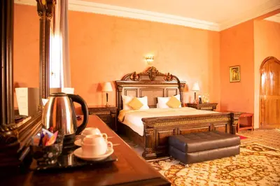 a bedroom with a bed and a table in a room at Palais Du Desert Hotel & Spa in Erfoud