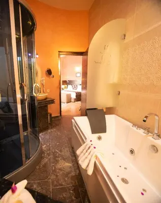 a bathroom with a tub and a shower and a sink at Palais Du Desert Hotel & Spa in Erfoud