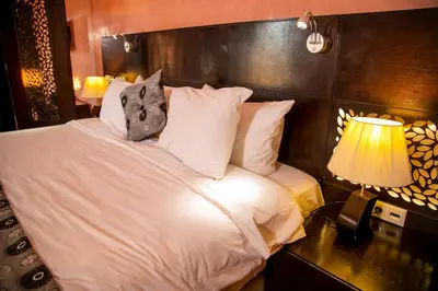 a bedroom with a bed with white sheets and pillows at Palais Du Desert Hotel & Spa in Erfoud