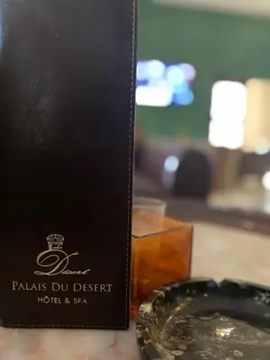 a black box with a drink next to a table at Palais Du Desert Hotel & Spa in Erfoud
