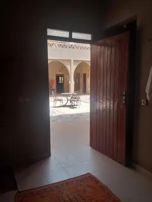 an open door to a room with a table at Hotel Riad Oasis in Merzouga
