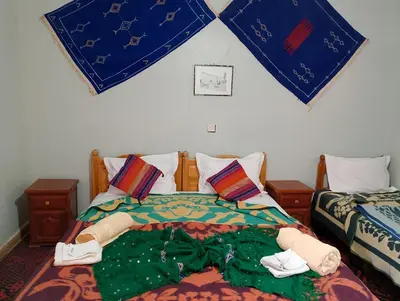 a bedroom with two beds with towels on them at Hotel Riad Oasis in Merzouga
