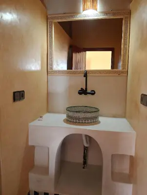 a bathroom with a sink and a mirror at Hotel Riad Oasis in Merzouga