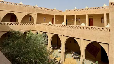 a building with arches and a bridge at Hotel Riad Oasis in Merzouga