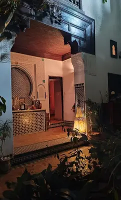 a living room with a large mirror on the wall at Riad Felloussia in Meknès