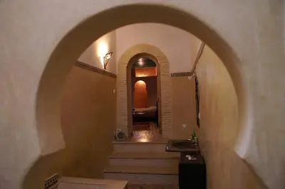 an arched hallway with stairs in a building at Riad Felloussia in Meknès