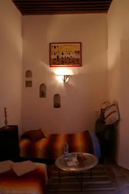 a room with a bed and a table in it at Riad Felloussia in Meknès