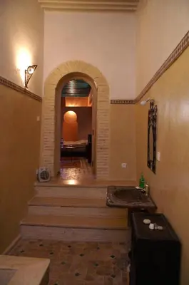 a hallway with stairs and a room with a bed at Riad Felloussia in Meknès