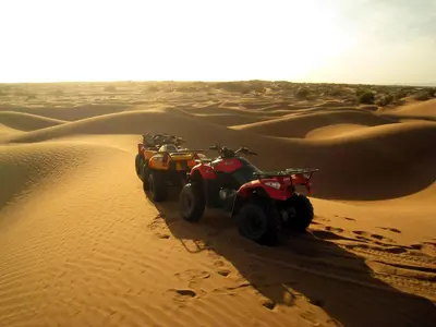 two atvs driving through the sand in the desert at Le Drom'blanc in Mhamid