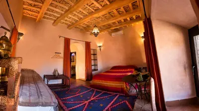 a bedroom with a bed and a rug in a room at Dar Bladi in Ouarzazate