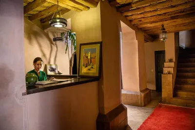 a woman sitting at a counter in a room at Dar Bladi in Ouarzazate