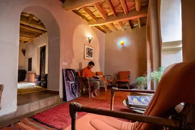a woman sitting at a table with a laptop in a room at Dar Bladi in Ouarzazate