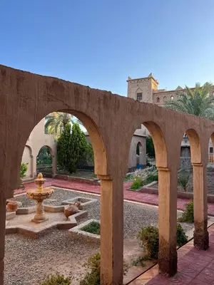 a stone bridge with a fountain in a courtyard at Dar Es Salam in Skoura