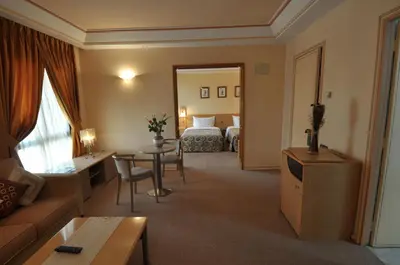 a hotel room with a bed and a living room at Hôtel Wassim in Fès