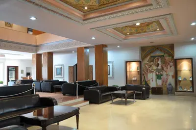 a waiting room with couches and tables and a ceiling at Hôtel Wassim in Fès